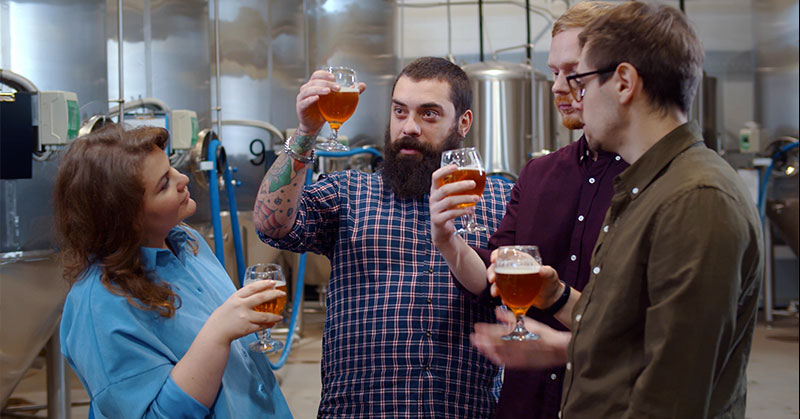 Young hipster people tasting fresh beer in modern brewery